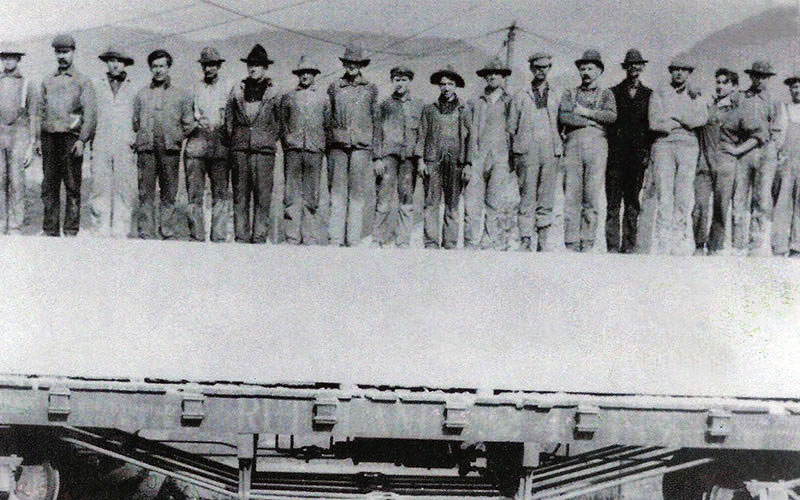 Quarry workers standing on top of a block of marble